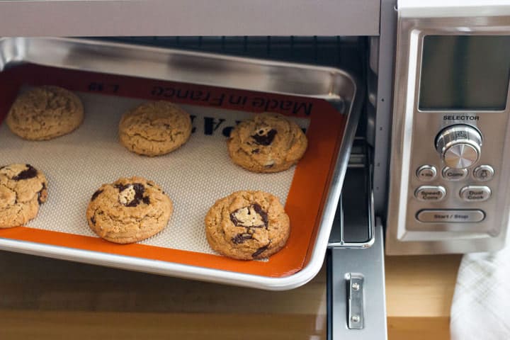 A baking sheet of cookies inside of a toaster oven.