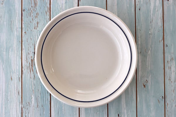 A ceramic pie plate on a wooden table.