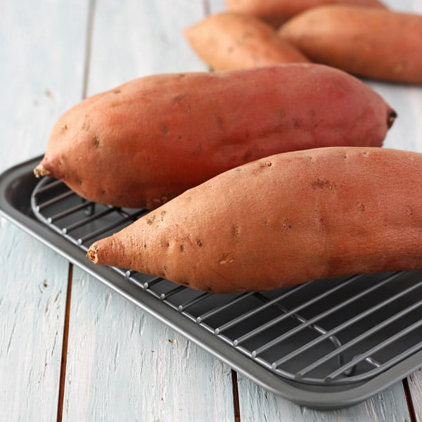 Raw sweet potatoes on pan