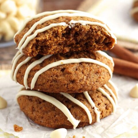 A stack of three cookies on a piece of white parchment paper.