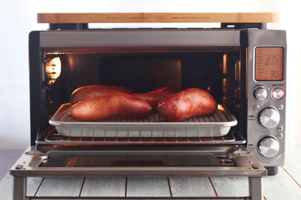 Sweet potatoes cooking inside a convection toaster oven