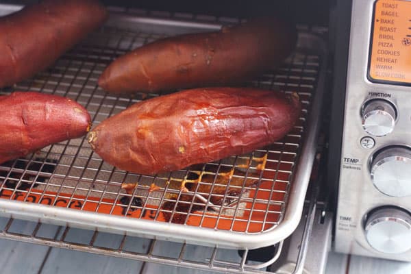 Sweet potatoes on a rack baking in a convection toaster oven