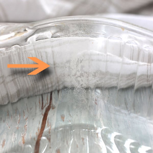 Arrow pointing to damage inside a glass baking dish.