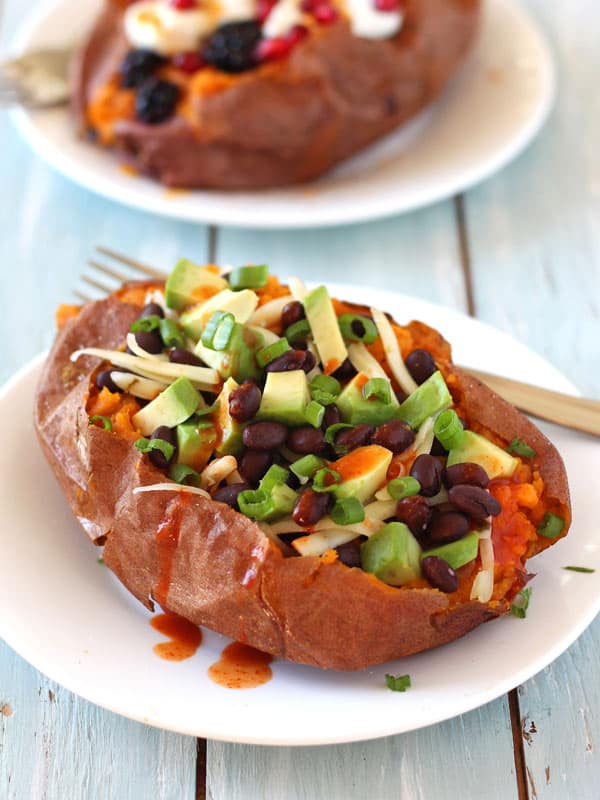 Baked sweet potato filled with black beans, avocado and drizzled with hot sauce