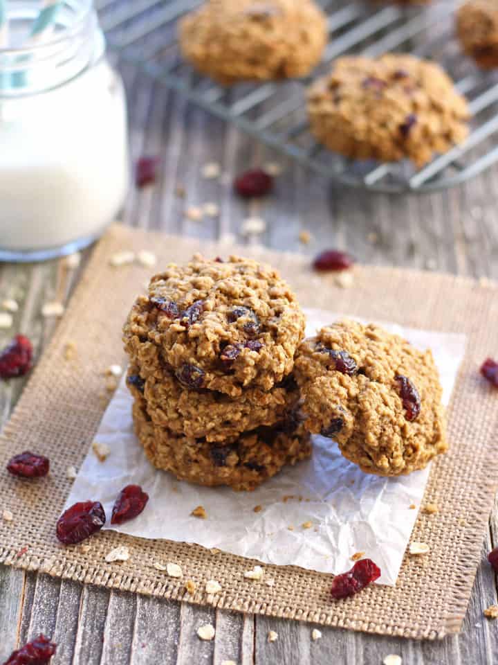 Stack of cranberry oatmeal cookies with a glass of milk.