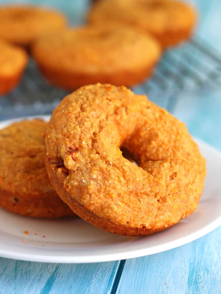 Baked cornbread donuts on a blue table.