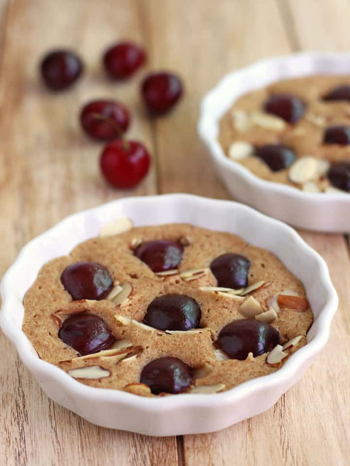 Mini baking dish with cake topped with sliced sweet cherries.