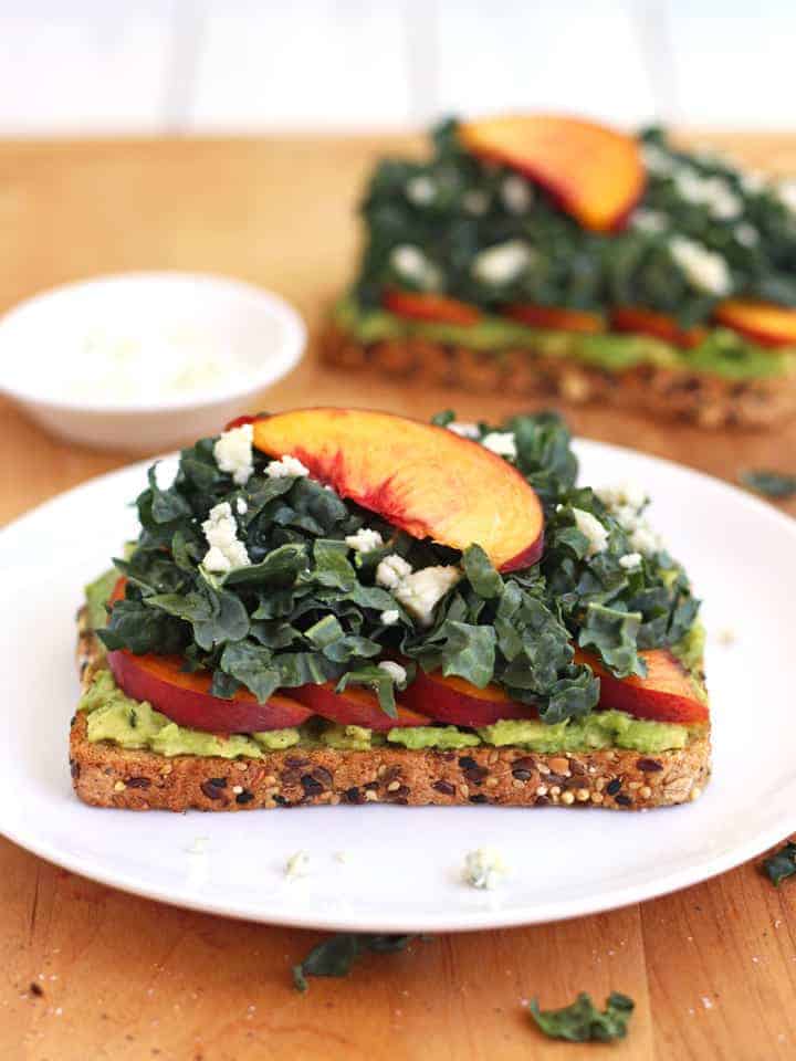 Avocado toasts on white plates.