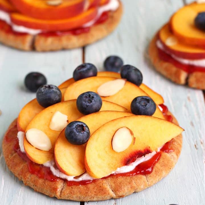 Pitas topped with ricotta, peach slices, and fresh blueberries.