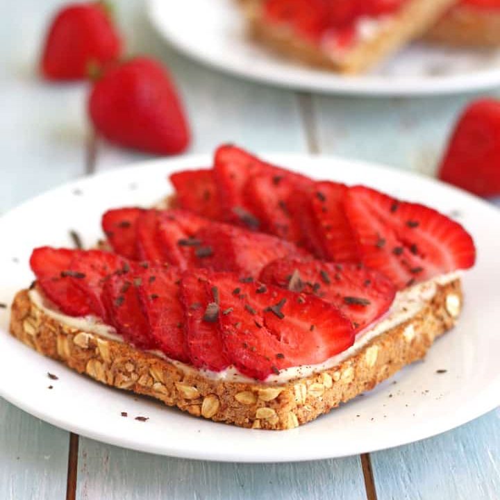 Toasts topped with fresh sliced strawberries and chocolate shavings.