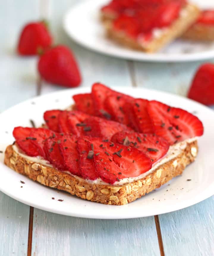 Toasts topped with fresh sliced strawberries and chocolate shavings.