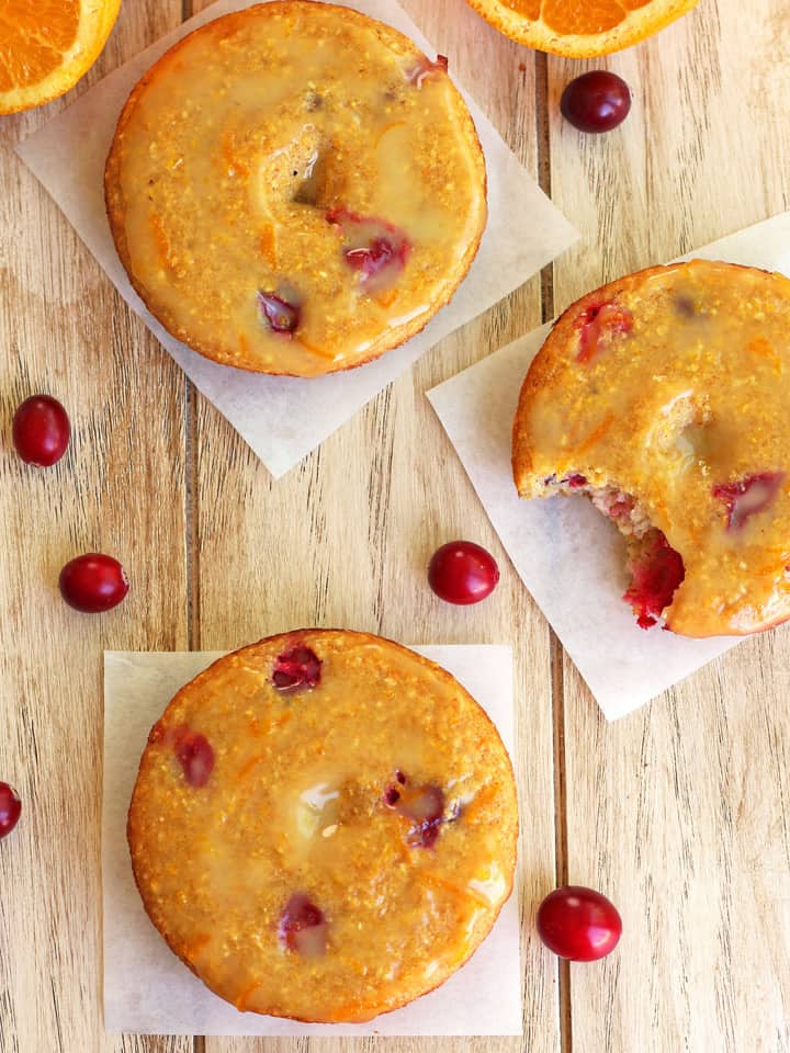 Overhead view of baked donuts surrounded by whole fresh cranberries.