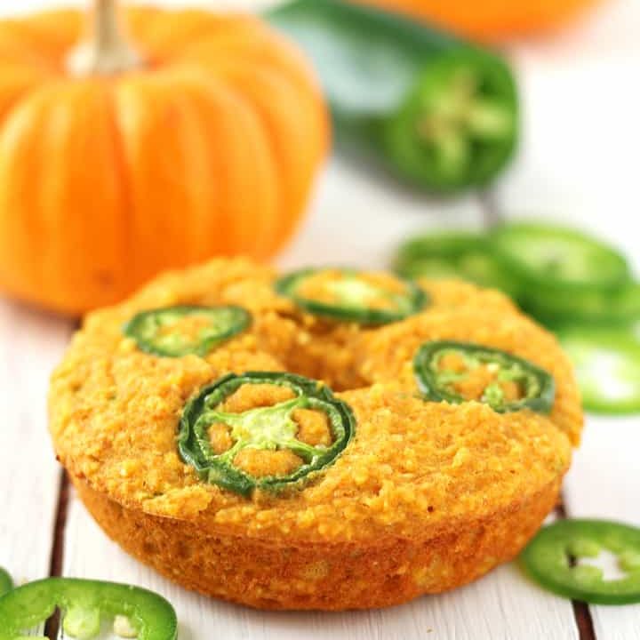 Cornbread donut topped with jalapeno slices net to a mini pumpkin.