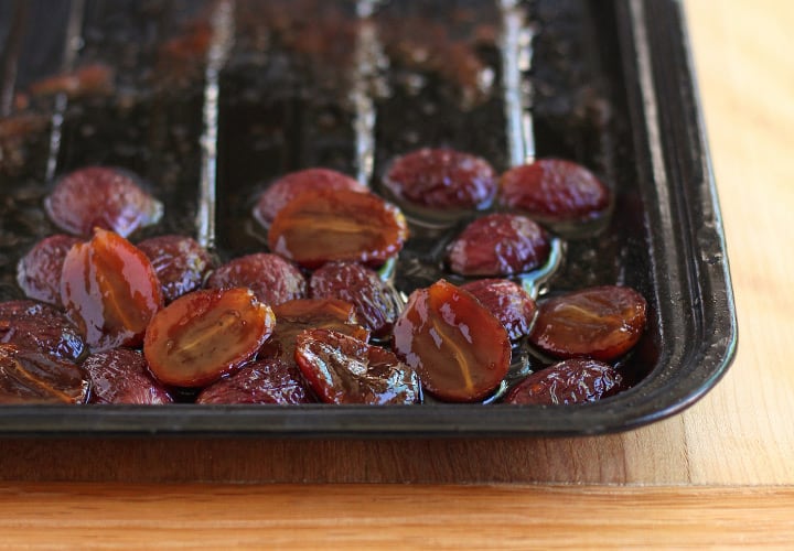 Roasted grapes on a sheet pan.