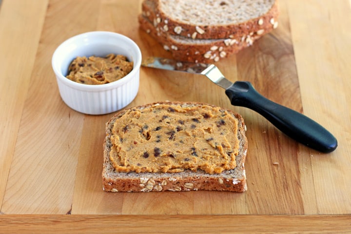 Cutting board with bread slices and a ramekin of pumpkin ricotta filling.