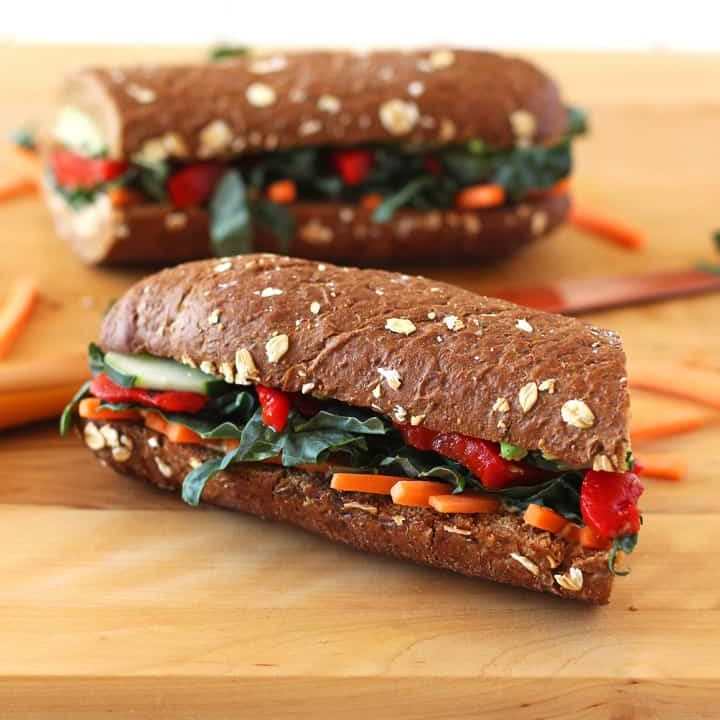 Cutting board with two vegetarian sandwiches.