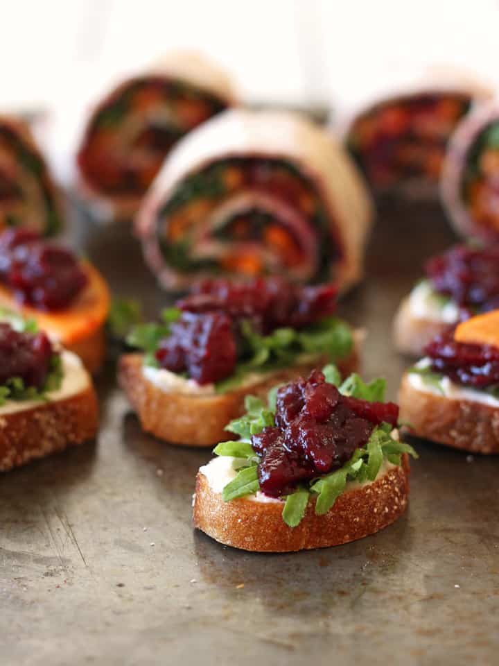 Crackers and pinwheels topped with roasted cranberries.