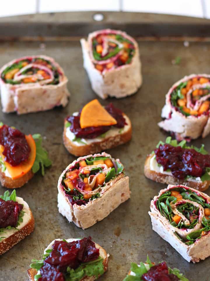 Pinwheels and crostini on a baking sheet.