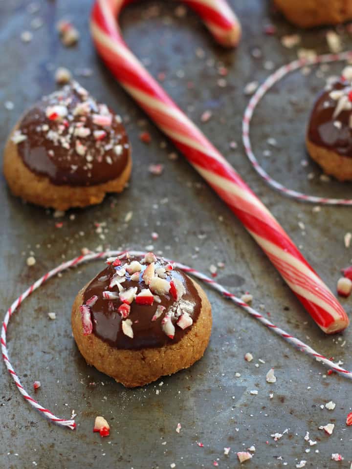 Peppermint shortbread cookies on a sheet pan with candy canes.