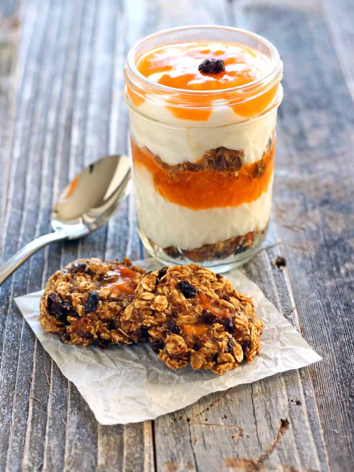 Oatmeal cookies with a jar of yogurt parfait with a spoon.