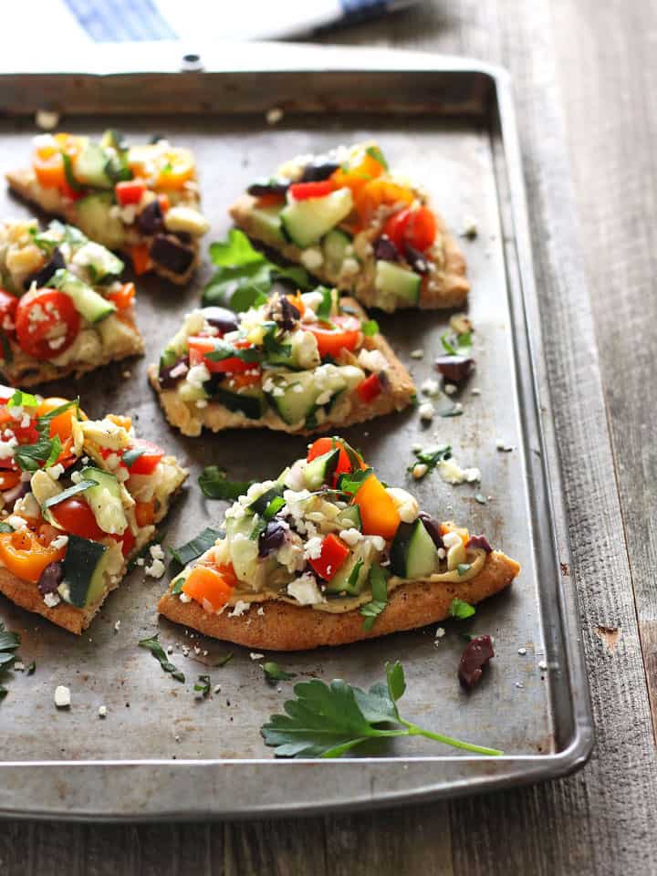 Sheet pan with topped slices of flatbread.