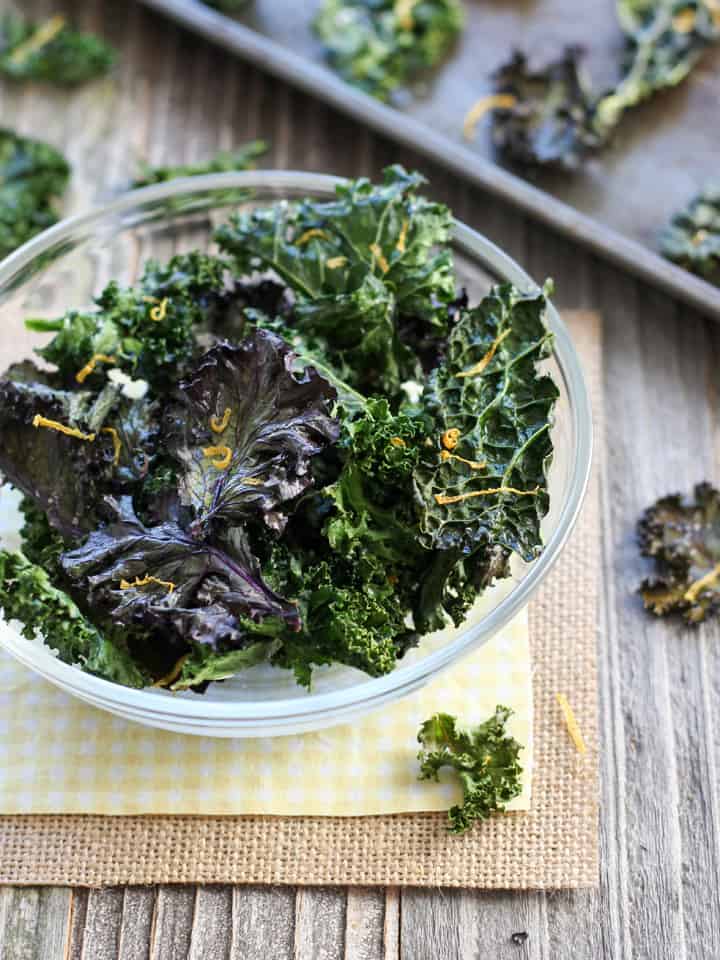 Baked kale chips in a glass bowl.