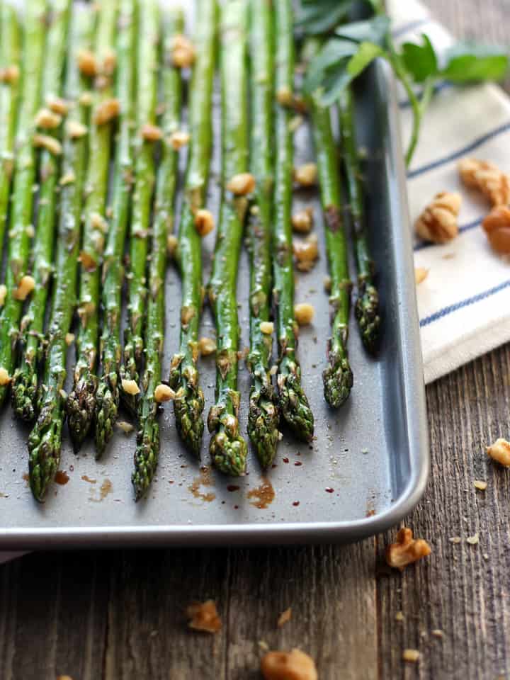 Roasted asparagus spears on a small sheet pan.