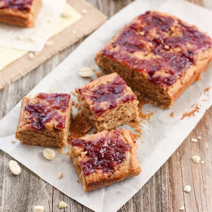 Peanut butter and jelly bars on a piece of parchment.