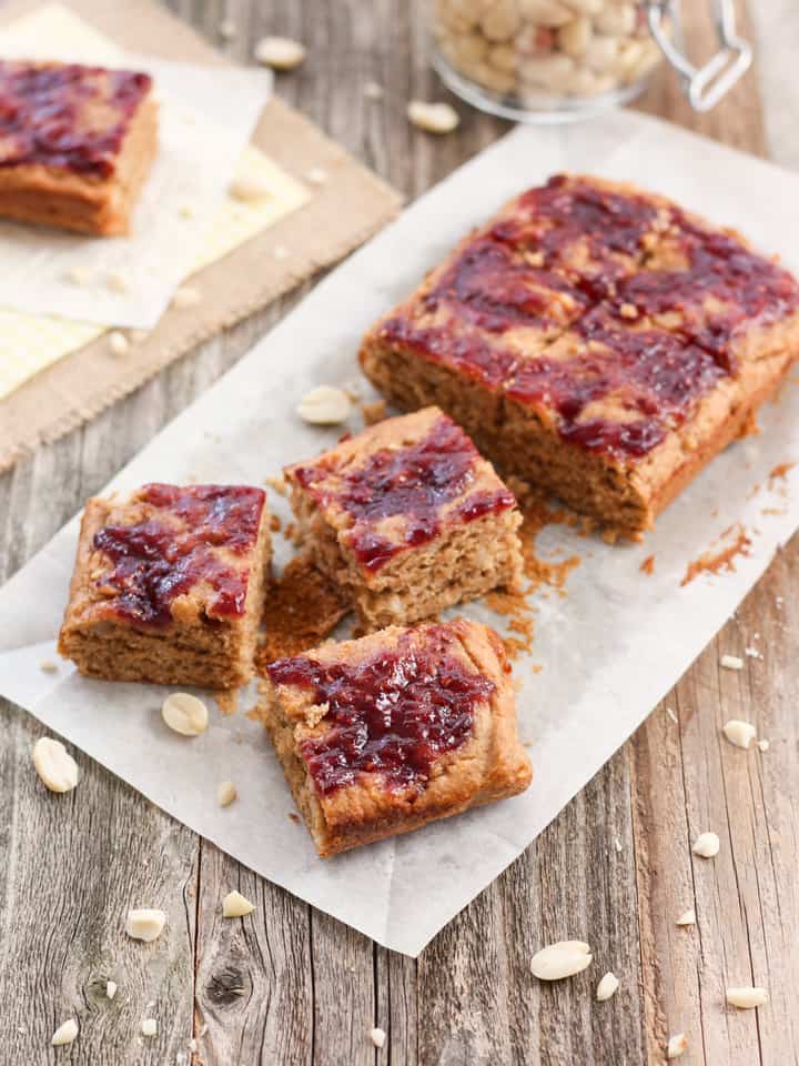 Peanut butter and jelly bars on a piece of parchment.