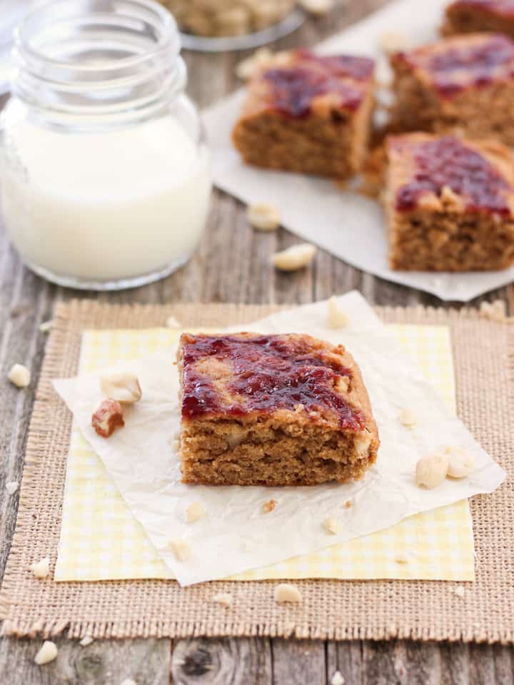 Peanut butter bar on a yellow napkin with a glass of milk.