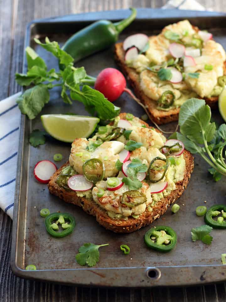 Close up of avocado and cauliflower topped toasts.