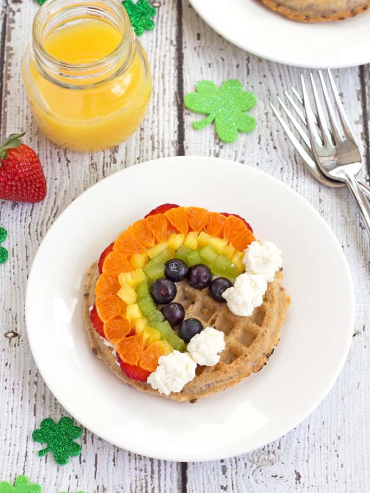 Fresh fruit arranged in the shape of a rainbow on a toasted waffle.