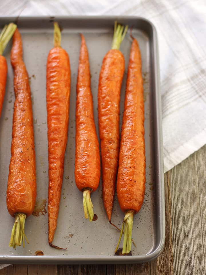 Roasted carrots on a small sheet pan.