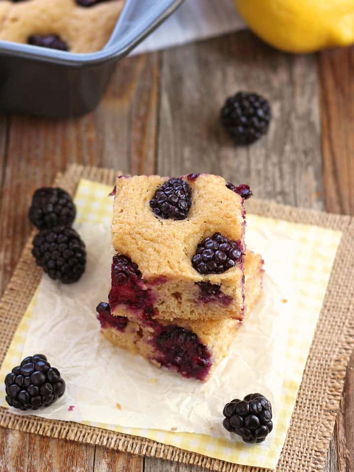 Pancake squares on parchment surrounded by fresh blackberries.