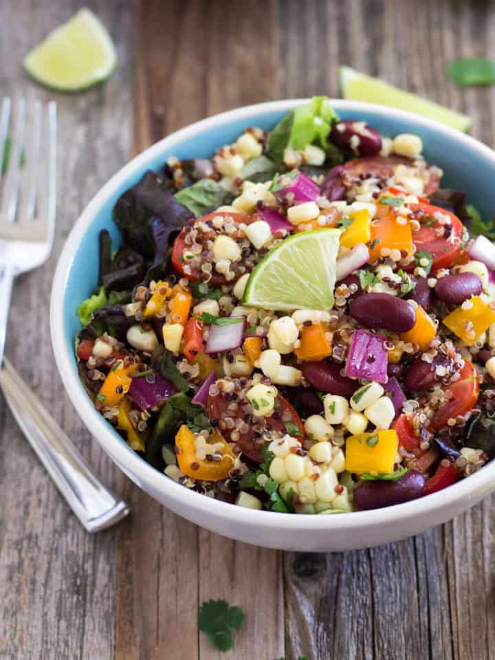 Blue bowl loaded with corn and quinoa salad.