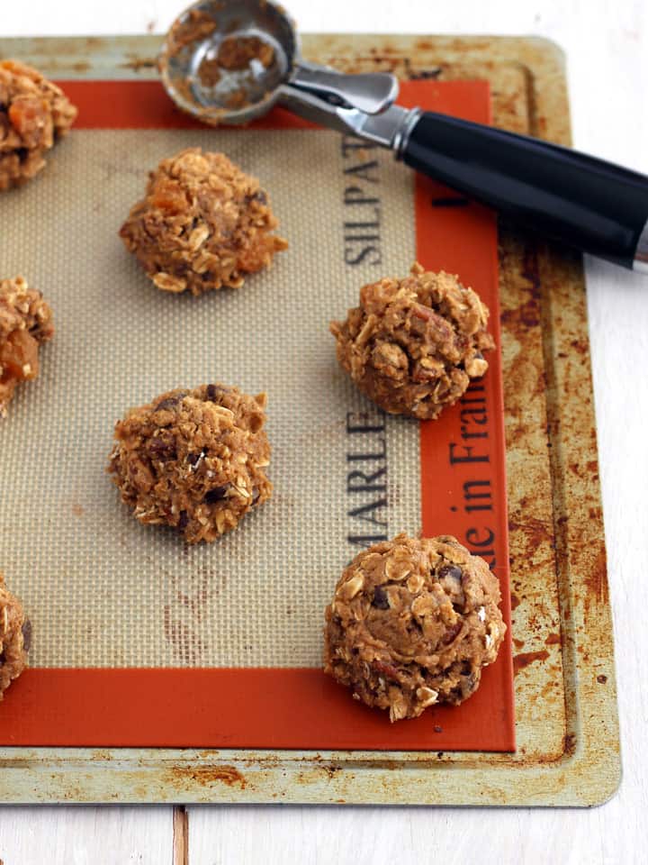 Raw cookie dough balls on a toaster oven baking sheet.