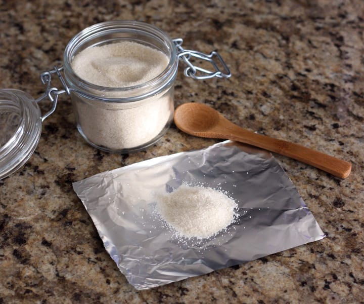 Pile of white sugar on a piece of foil.