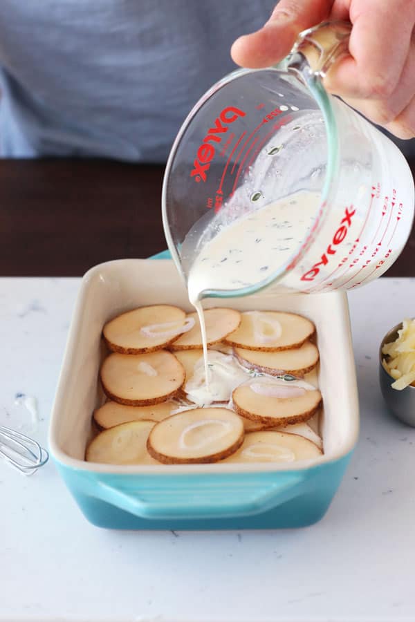 Cream being poured over a potato slices