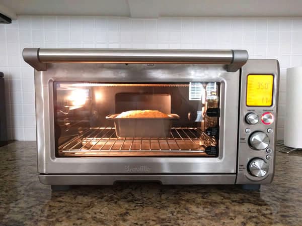 Mini loaf of of quick bread baking inside a toaster oven.