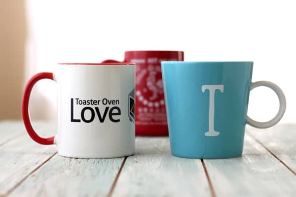 A variety of colored coffee mugs on a table.