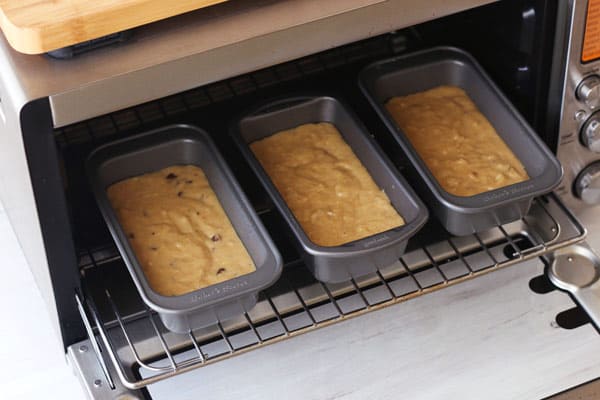 3 mini loaf pans full of batter inside of a countertop oven