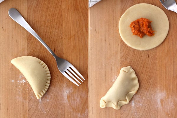 Folded and crimped hand pies on a cutting board.