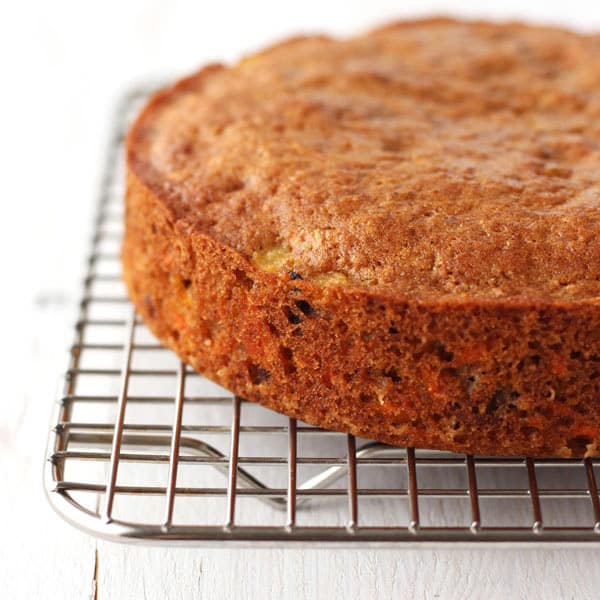 Round 6-inch carrot cake cooling on a wire rack.