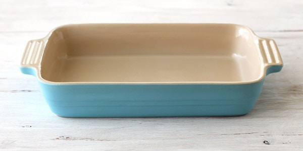 A large blue baking dish on a white table.