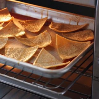 Tortilla slices baking in a toaster oven.