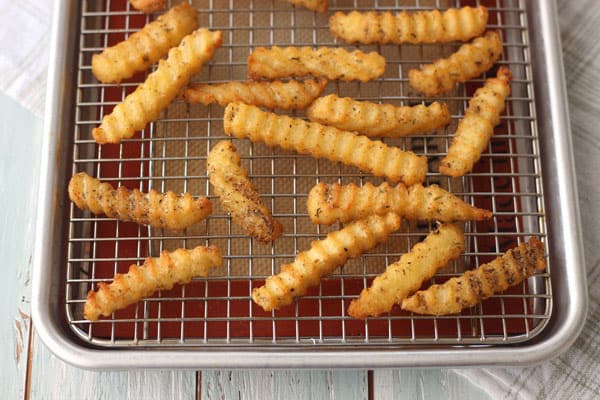 Crispy baked fries on a cooking rack.