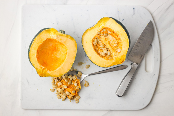 Overhead view of an acorn squash sliced in half with the seeds scooped out.