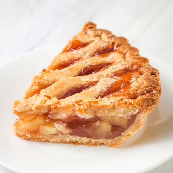 Thick slice of apple pie on a small white plate.