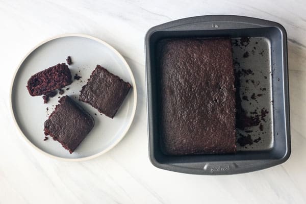 Slices of chocolate cake with crumbled bits on a plate.