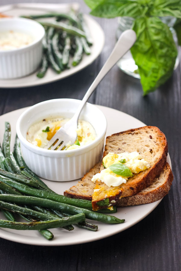 A plate of green beans and toast with creamy egg on top.